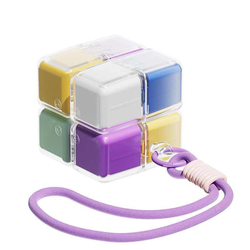 A portable medication organizer designed in the shape of a Rubik's Cube, featuring a lanyard for convenient carrying, a high-capacity dispensing compartment, and a sealed, moisture-resistant storage container organized for daily use across seven days.